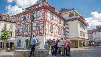Gästeführer mit Gruppe vor Fachwerkhäusern in Alzey am Fischmarkt