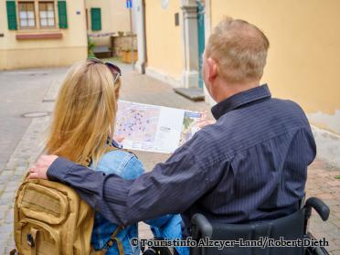 Gäste im Rollstuhl mit Stadtplan - Foto von Touristinfo Alzeyer-Land/Robert Dieth