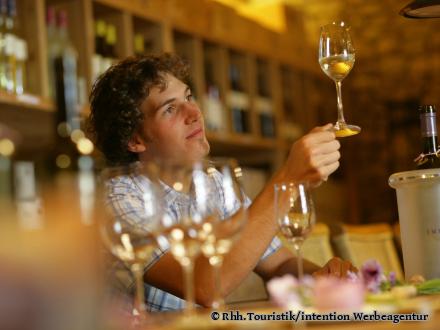 Ein junger Mann betrachtet den Wein in seinem Glas - Foto von ©Rhh.Touristik/intention Werbeagentur