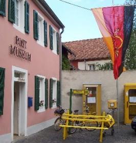 Außenansicht Postmuseum mit gelber Telefonzelle